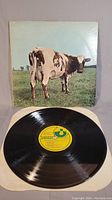 Front cover of the LP with the iconic cow on grass field, showing some wrinkling and wear on edges