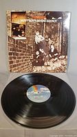 Photo of the album cover showing The Who band in a brick alley with the album title 'Meaty Beaty Big And Bouncy' on top.
