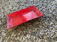 Top angle photo of the small rectangular tray showing red glossy finish and textured surface.