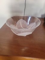 Clear glass bowl featuring an etched floral petal design visible on the exterior surface.