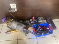 Main unit, extension wand and assortment of attachments displayed on floor