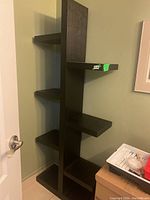 Full view of the faux wood bookshelf showing staggered shelves and overall shape.