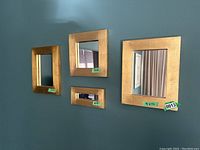 Four gold wooden painted mirrors hung on a wall showing size labels 9x12, 9x9, 4x7, and 8x4 inches.