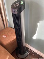 Full view of the Seville Classics oscillating tower heater showing black and silver tower fan design with vertical vents and power cord.