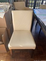 Front view of a single armless dining chair showing seat and back upholstery