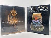 Front covers of the two Art Nouveau books standing upright side by side on a plain surface.