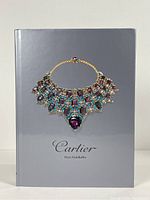 Front cover of the Cartier reference book showing a multicolored gemstone necklace.
