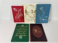 Five hardcover volumes with different cover designs arranged upright showing front covers and shadows beneath.