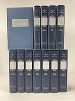 Twelve slipcases arranged in two rows showing uniform navy cloth and gilt spine decoration
