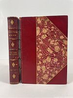 Front cover and spine of volume 1 showing half red Morocco leather and marbled boards, with gold gilt text and fleur-de-lis on spine.