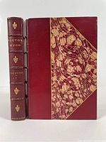 Front cover and spine of Volume I showing red Morocco leather and marbleized cover, gilt text and designs on spine, 'Centenary Edition' label.