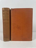 Front cover of 'Some Experiences of a New Guinea Resident Magistrate' showing brown cloth cover with texture and wear.