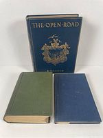 Front view of three books: The Open Road standing behind two other books, one green and one blue, all hardcover.