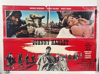 Wide view of Johnny Hamlet poster showing man aiming rifle and reclining woman with scenic background.