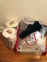 Overview of the batting rolls, felt pieces and plastic bin on the floor, showing contents of the lot.