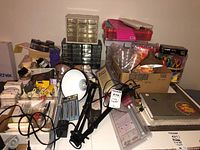 Wide shot showing multiple craft supplies items arranged together including organizers, lamp, cutting tools, and thread.