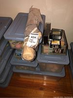 Stacked plastic bins filled with various threads and fabric rolls with a tag labeling 'Craft Supplies'.