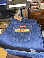 Folded Levi's 619 blue denim jeans with tags showing size 36x32 and leather brand label on waistband.