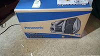 Sealed Panasonic SC-PM31 box with front view showing speakers and main unit illustration