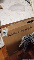 Box of Dream World Sew Steady Portable Table standing upright on a bed
