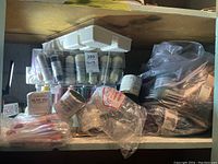 Top shelf showing spools of thread in clear organizer, packs of ribbon, and Blue Fez yarn rolls