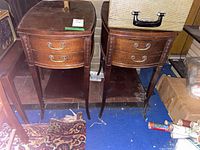 Front view of both side tables showing curved fronts, drawers, lower shelves and carved legs