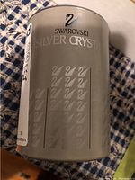 Cylindrical frosted box with Swarovski Silver Crystal logo and branding.