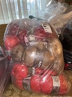 Plastic bag filled with red and beige Patons Dazzle yarn skeins visible through the bag
