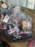 Large clear bag filled with several skeins of Patons True North yarn in taupe color wrapped with labels.