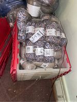 Two clear plastic totes with red lids filled with yarn