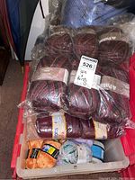 Top-down photo of the tote filled with various yarn skeins including a visible label of Patons Dream Sweater yarn in red-black-grey variegated colorway.