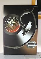 Close-up photo of lithograph depicting vintage record player stylus on Pathé record label, showing colors and design