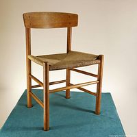 Full view of the J39 People's Chair showing the oak frame and woven paper cord seat from an angled perspective.