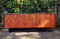 Full front and side view of teak credenza outdoors against backdrop of leaves