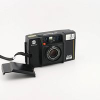 Front view of Minolta 35mm Auto Focus camera showing lens, flash, and original face plate with open film compartment door.