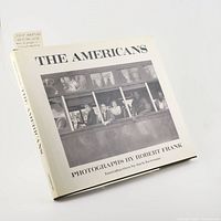 Front cover of The Americans book showing dust jacket with black and white photo of bus passengers.