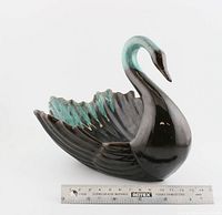 Front and left side view of vintage ceramic swan with black and green glaze, placed next to a measuring ruler showing about 19cm length.