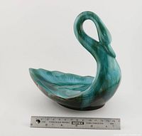 Front and side view of ceramic swan dish with ruler showing size and shape.
