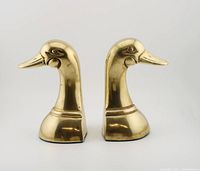 Front side view of the solid brass duck head bookends showing detailed profiles and polished finish.