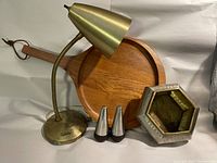 Photo showing the full lot: brass desk lamp, teak serving tray, salt and pepper shakers, and hexagonal planter on neutral background