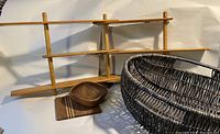 Foldable teak shelf with multiple angles showing its structure and condition. Blue woven basket, small wooden bowl, and wooden serving board placed in front.