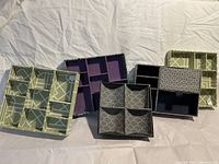 Set of five fabric jewelry/drawer organizers in various sizes and patterns on white sheet.