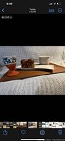 Side view of the teak tray with salt and pepper shakers, pottery goblet, plant pot all on tray, placed on fabric surface.