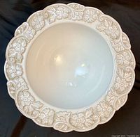 Top view of the bowl showing ornate floral relief border and smooth glazed interior surface.