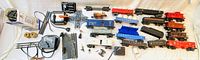 Full overview of the lot showing all train set parts, cars, electrical components, and accessories laid out on white surface with ruler for scale.