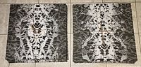 Two grey and white FLOR carpet squares side by side, showing the symmetrical abstract pattern and tied with string.