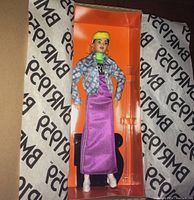 Black Label Barbie doll in neon motorcross dress inside original orange box with clear plastic front, showing full outfit and details.