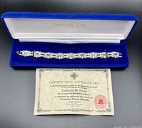 Bracelet displayed in blue velvet box with certificate of authenticity in foreground