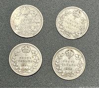 Four Canadian silver 5 cent coins dated 1903, 1907, 1911, and 1920 arranged on dark surface.