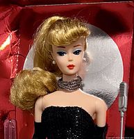Front view of the Solo In The Spotlight Barbie doll in original red display box with black sequin gown and accessories visible.